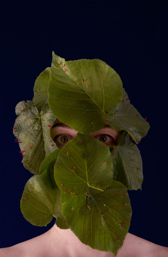 Femme recouverte de feuilles avec insectes rouges